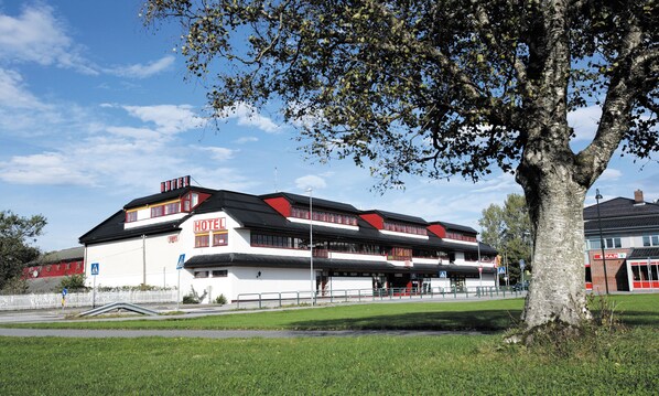 A hotel with a white facade, red accents, and a sign indicating a pub. - Thon Hotel Baronen (Ålesund)