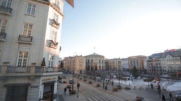 A city square with historic buildings, a grand cafe, and a statue.