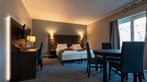 A hotel room with a bed, bedside tables, a desk, and a dining area. - Thon Hotel Måløy (Kinn)