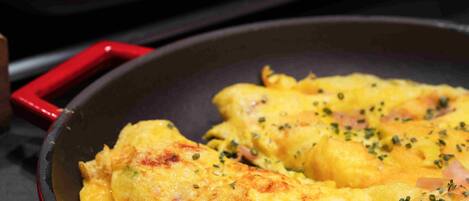 A skillet with scrambled eggs and a tray of fried eggs.
