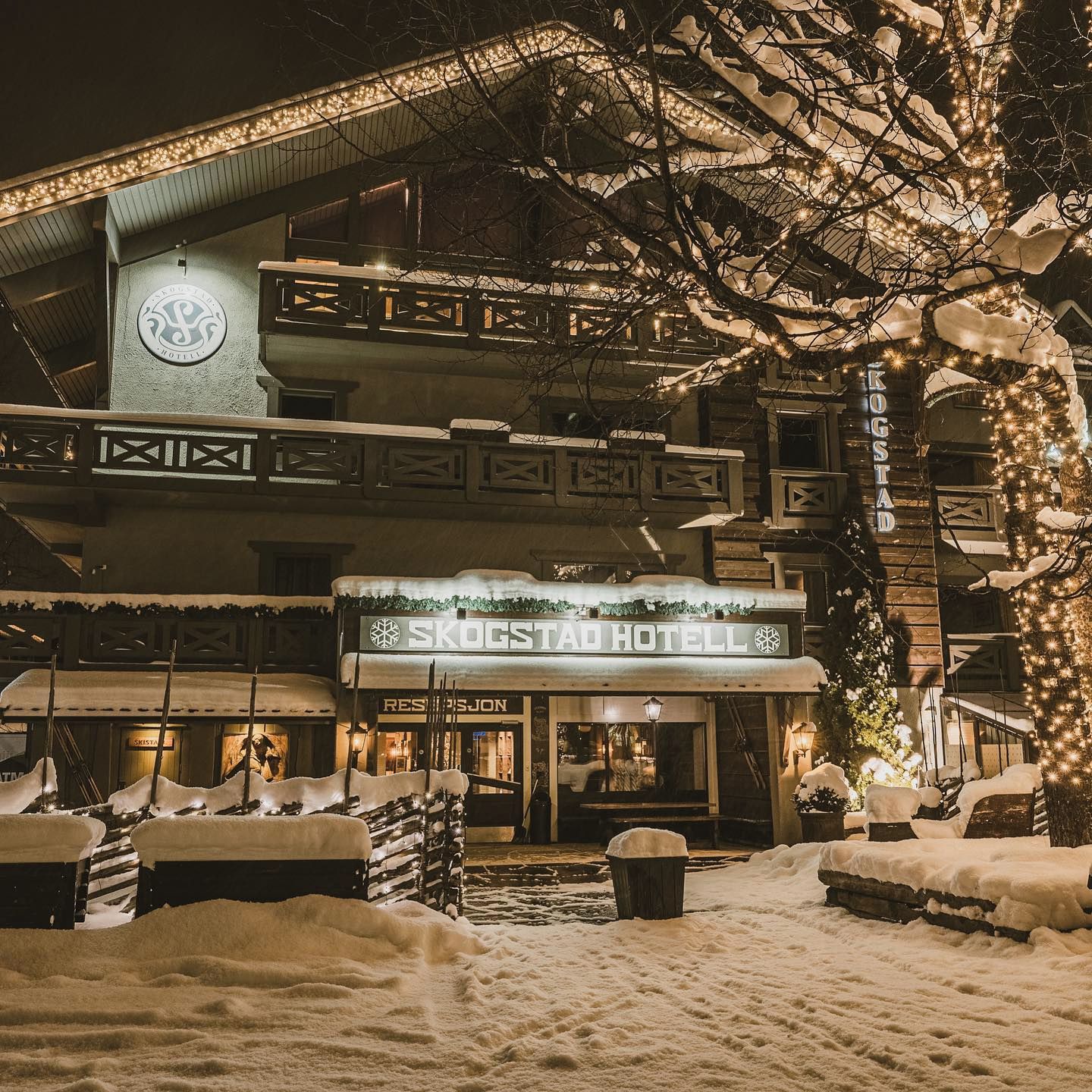 A hotel with a sign reading 'SKOGSTAD HOTEL' and a visible entrance.