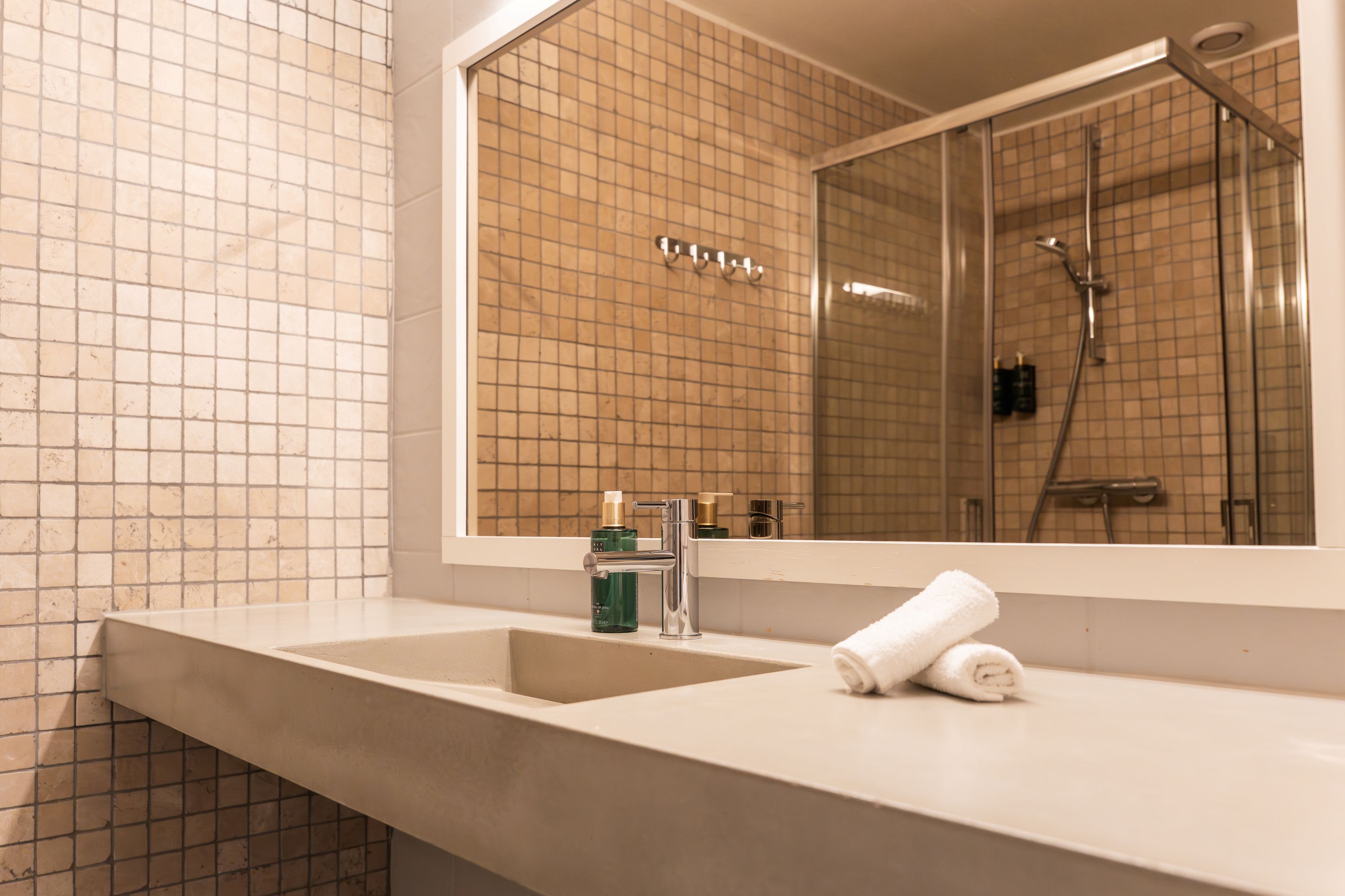 A bathroom with a large mirror, two sinks, and a shower.