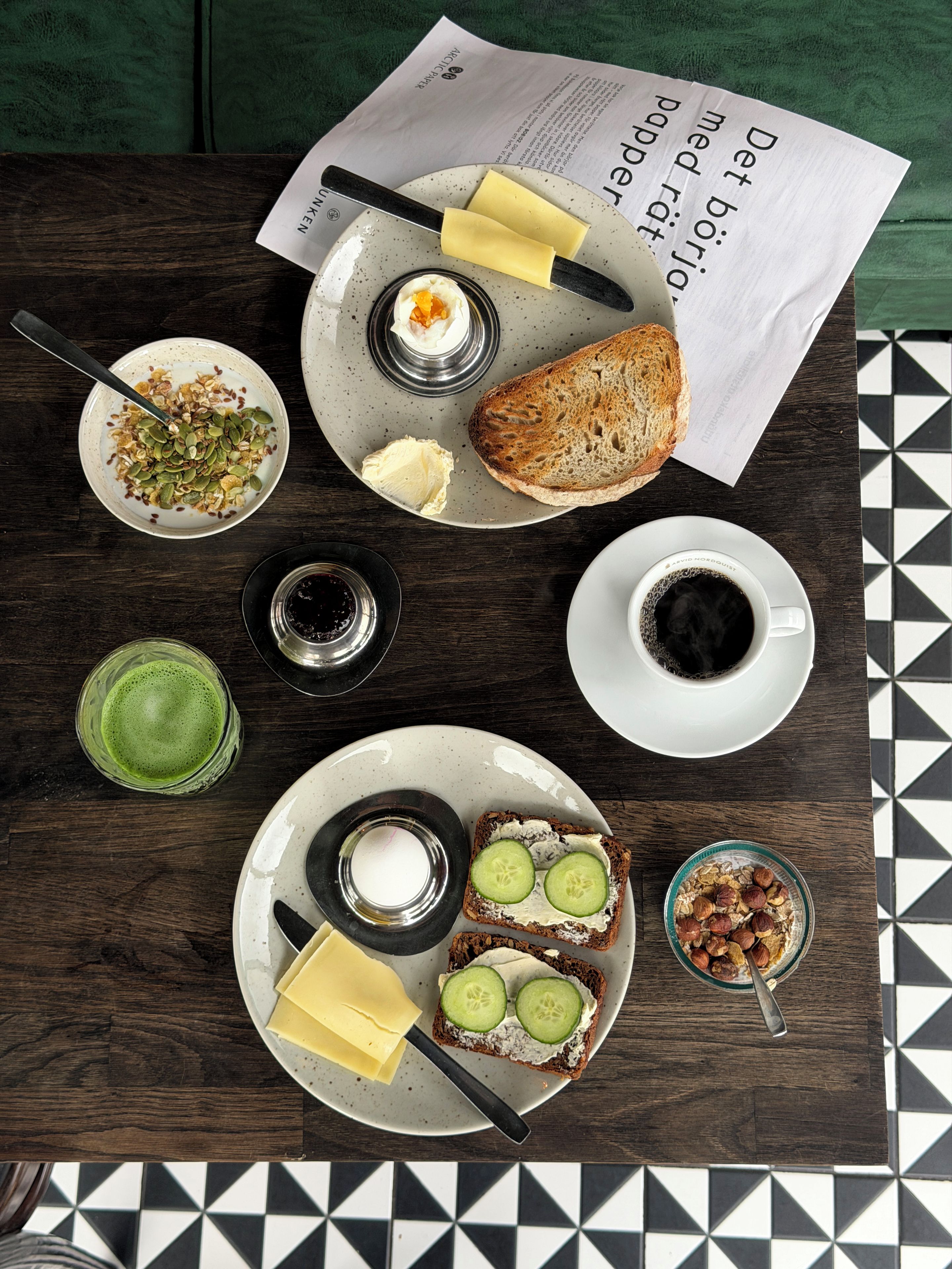 Mesa posta para o café da manhã, com diversos alimentos e um jornal.