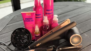 A table with hair styling tools and Proffs hair care products.