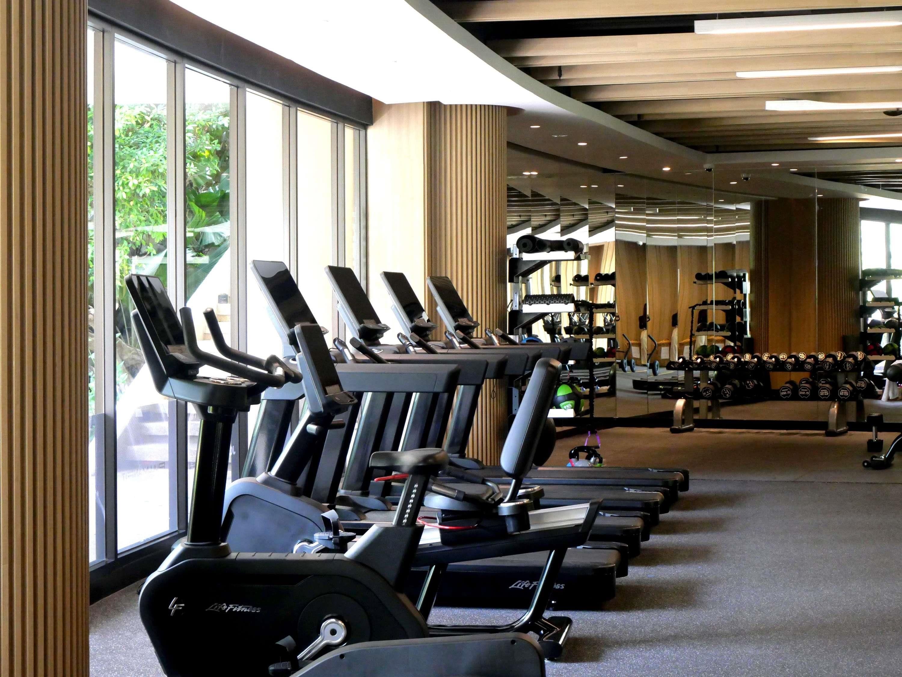 A gym with multiple treadmills, weight machines, and free weights.