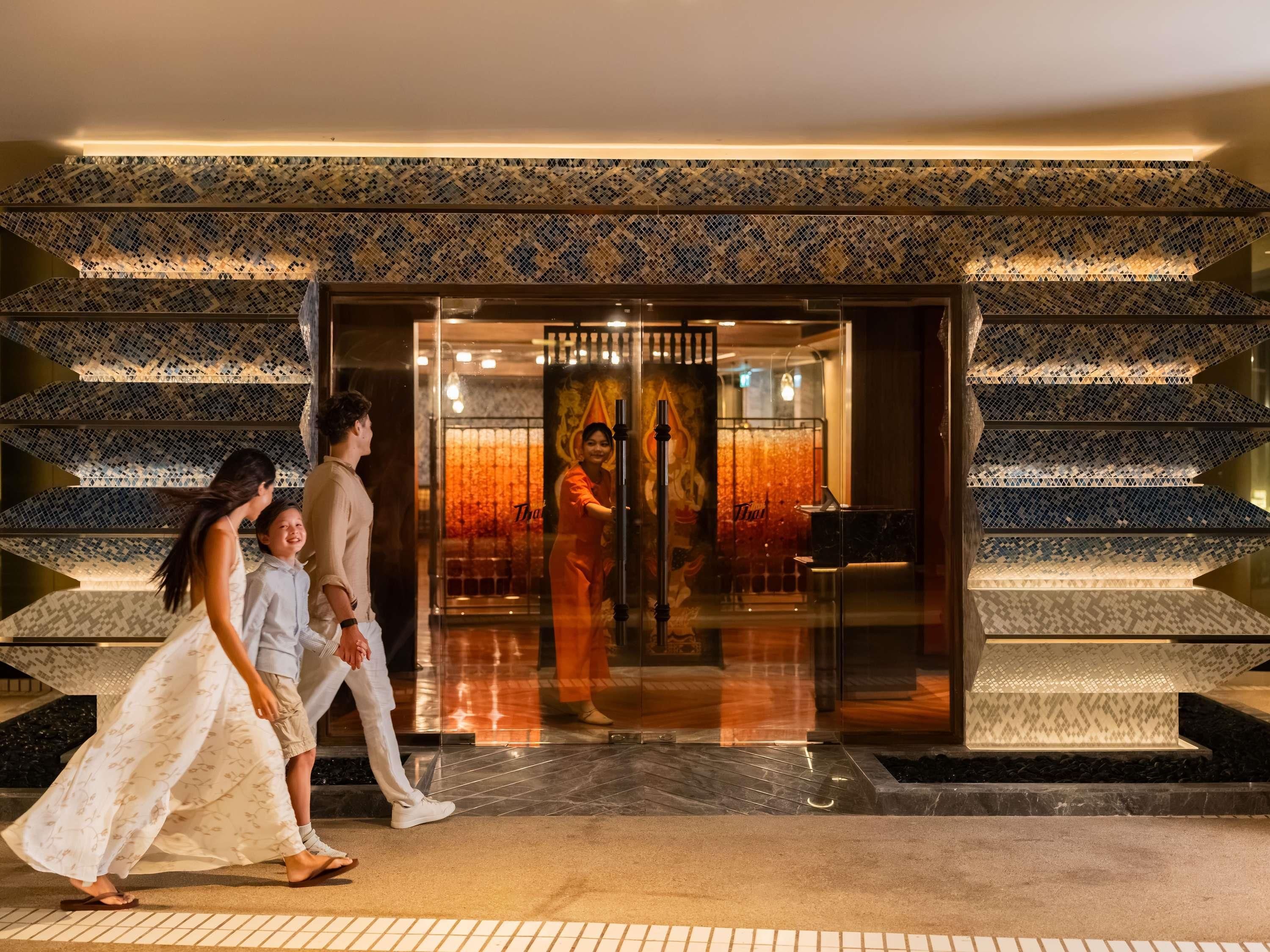 A hotel entrance with a patterned facade and a glass door.
