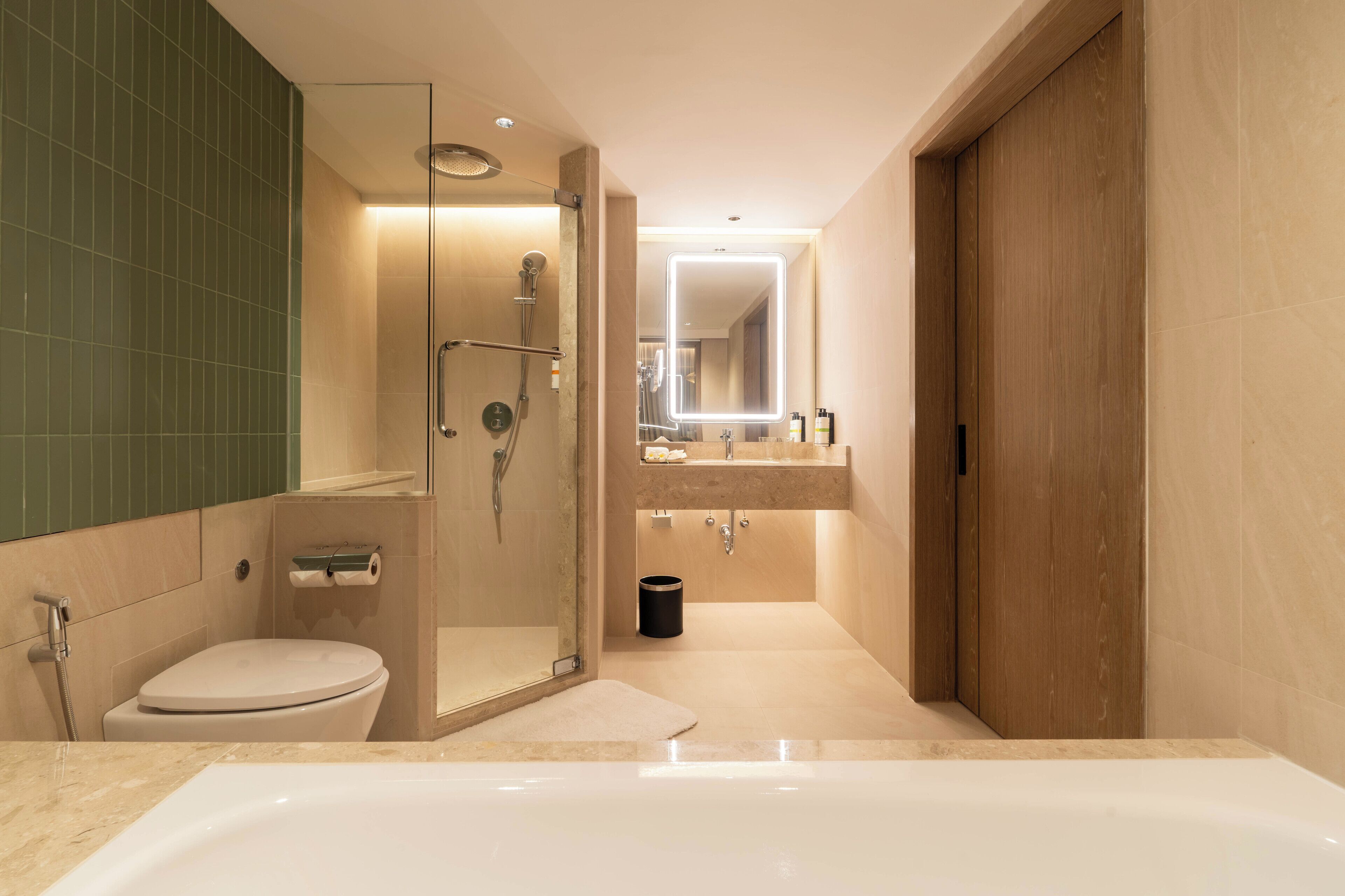 Un baño moderno con cabina de ducha, inodoro, bañera y tocador con espejo.