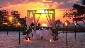 A beachside dining setup with a canopy, white chairs, and tables, overlooking the sea. - Pullman Phuket Karon Beach Resort (Karon)