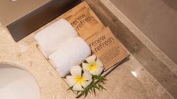 A bathroom with a tissue box, a towel, and a box of 'renew fresh' products.