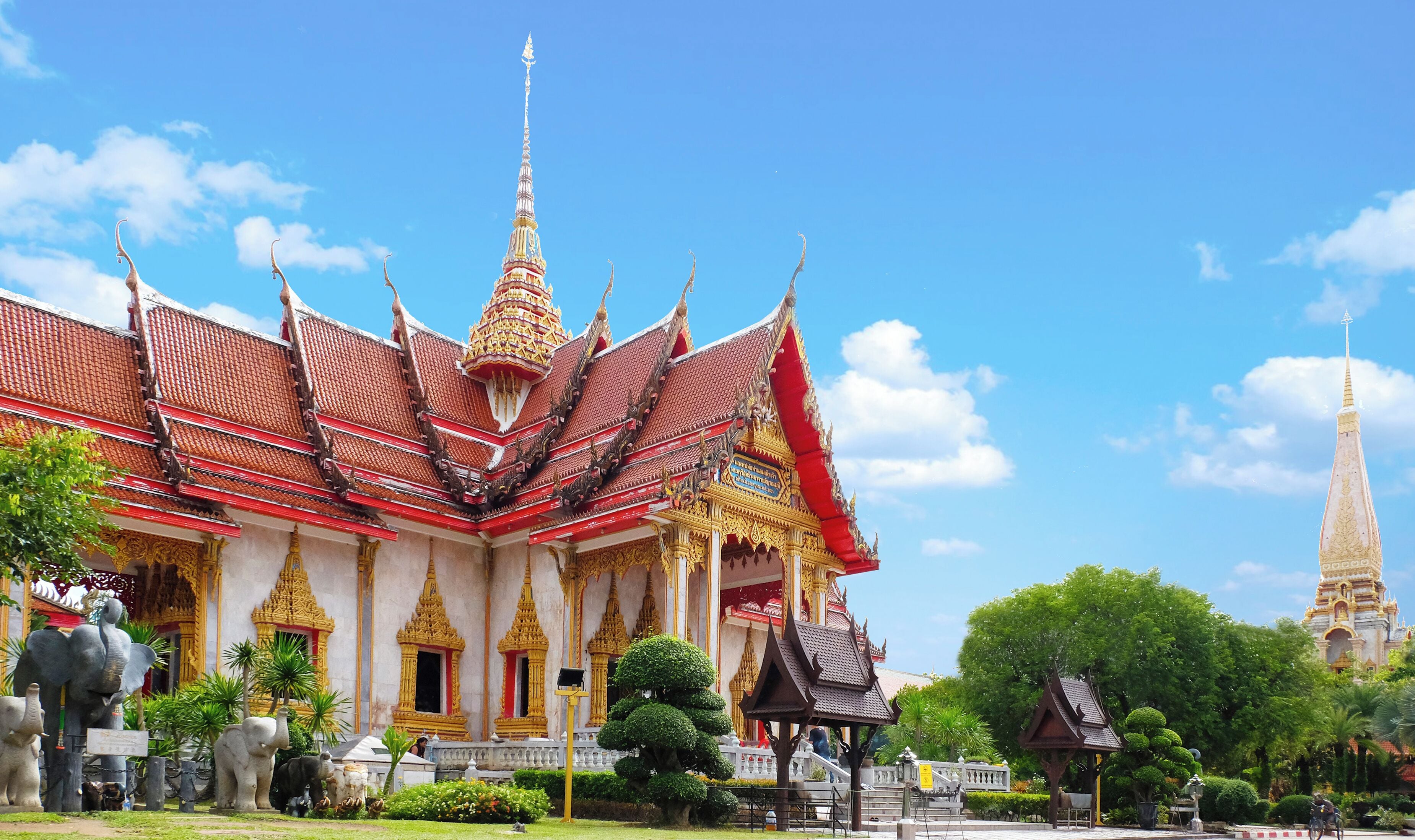 Et traditionelt thai tempel med overdådig arkitektur, herunder et tag i flere niveauer og gyldne dekorationer.