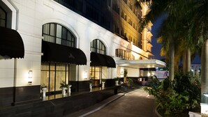 Fachada imponente de un hotel, con amplias ventanas y una entrada curva.