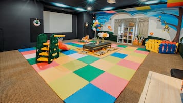 Children can play and learn in this vibrant playroom featuring a playpen, table, and bookshelf.