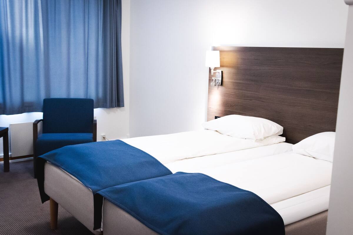 Una habitación de hotel con una cama, un escritorio y una silla.
