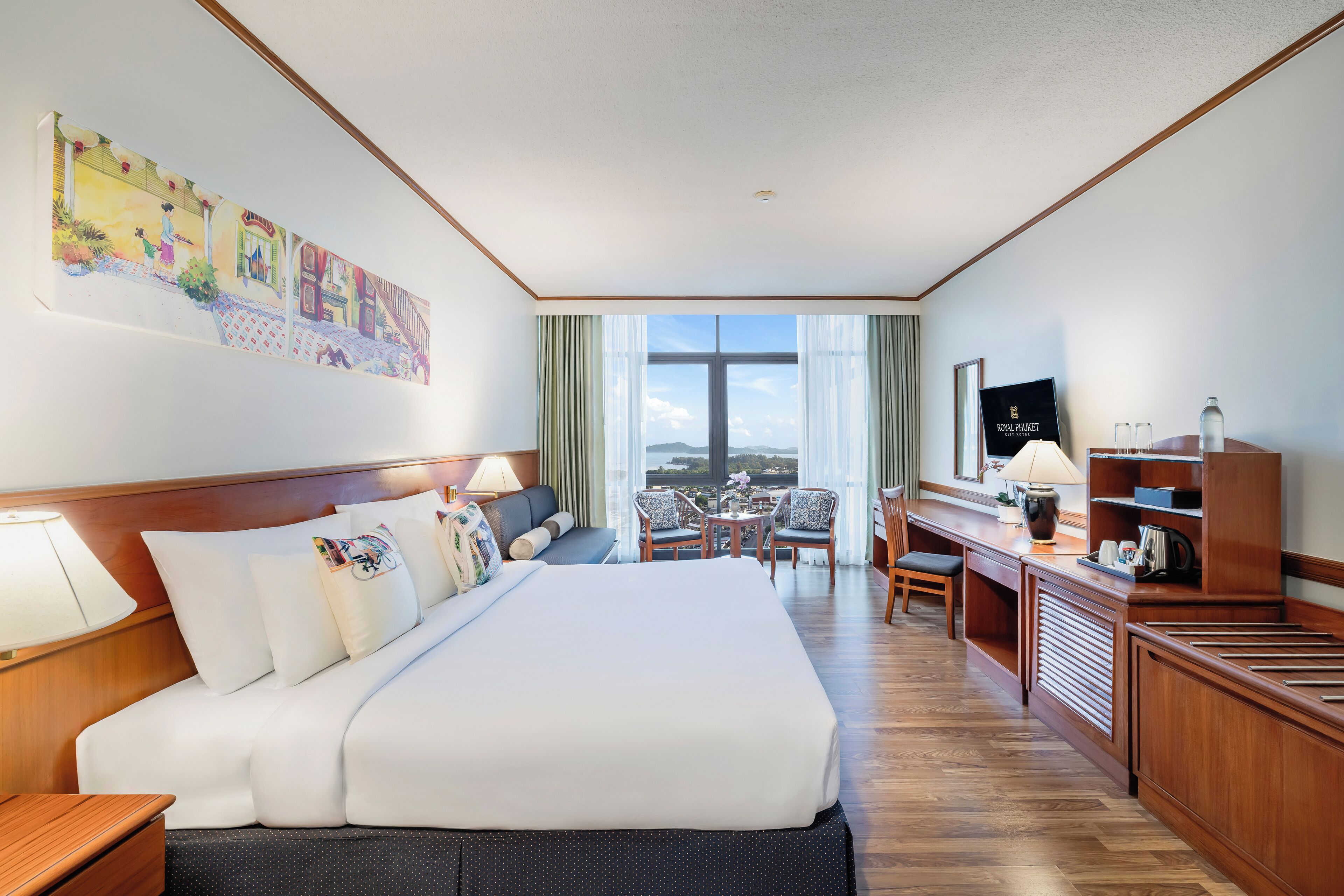 Habitación de hotel con una cama grande, un escritorio con computadora, una silla y vistas a la ciudad.