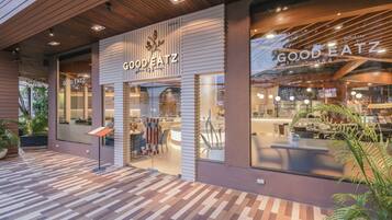 Un restaurant moderne, doté d’une façade en bois et de grandes fenêtres en verre.