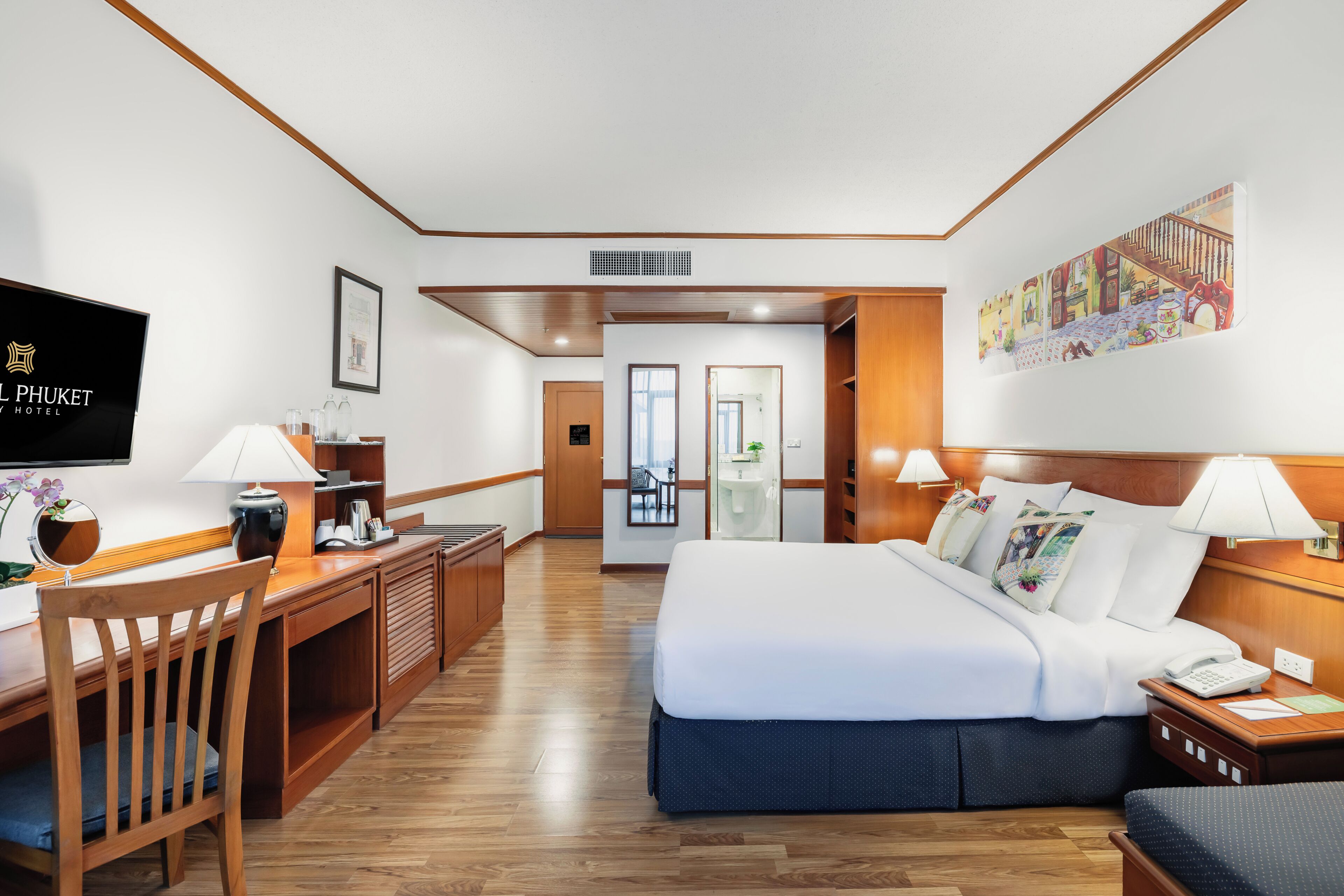 A hotel room with a bed, desk, chair, TV, and artwork on the wall.