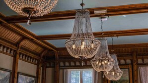 A dining area with wooden paneling, chandeliers, and framed artwork on the walls. - Thon Hotel Sandven (Kvam)