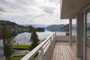 En balkon med udsigt til sø og bjergene.
