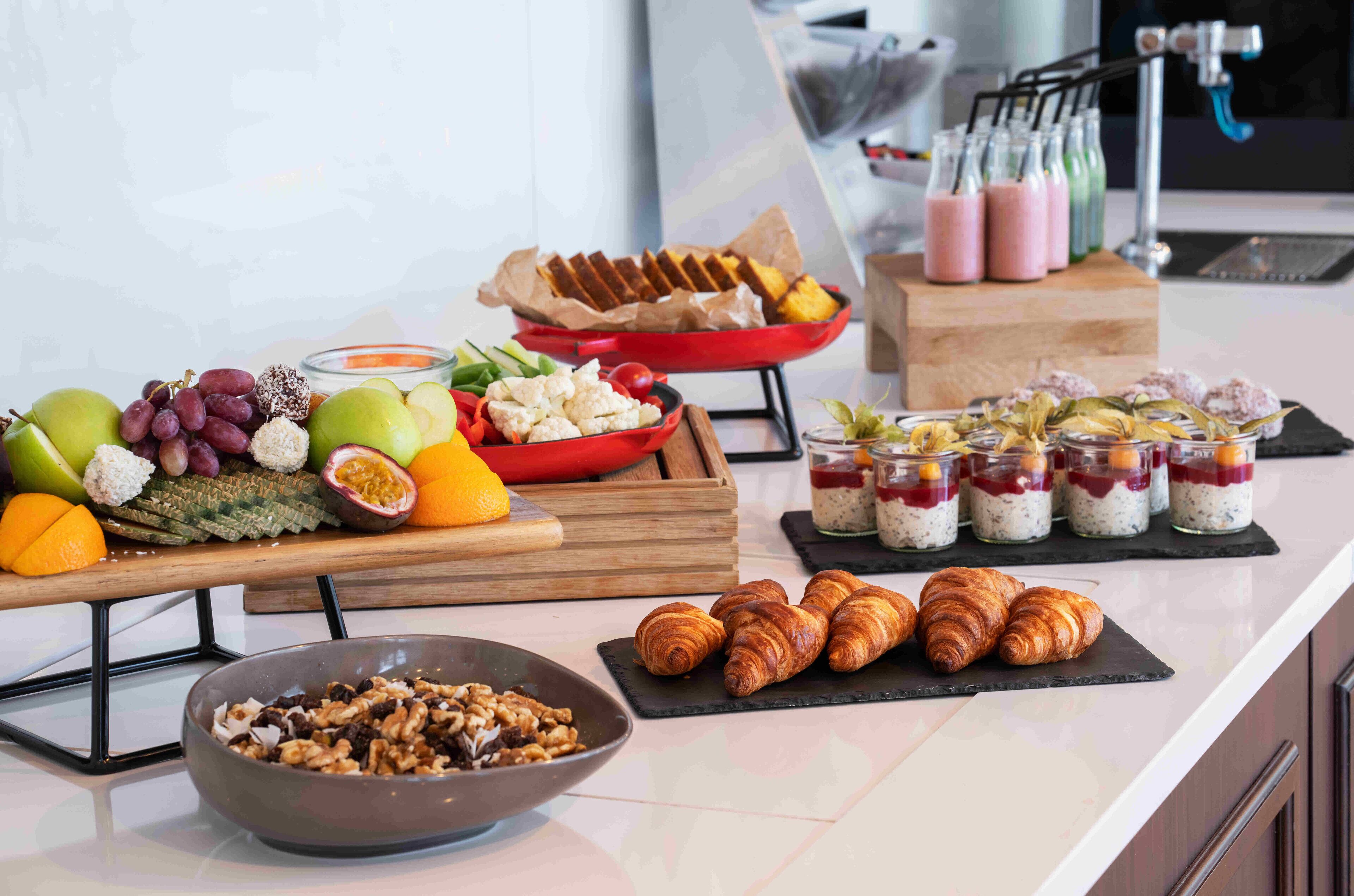 A breakfast buffet with fruits, pastries, and beverages.
