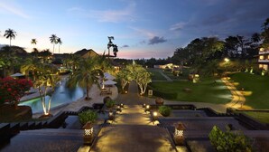 A resort with a swimming pool, well-lit pathways, and lush landscaping. - Grand Luley Manado (Manado)