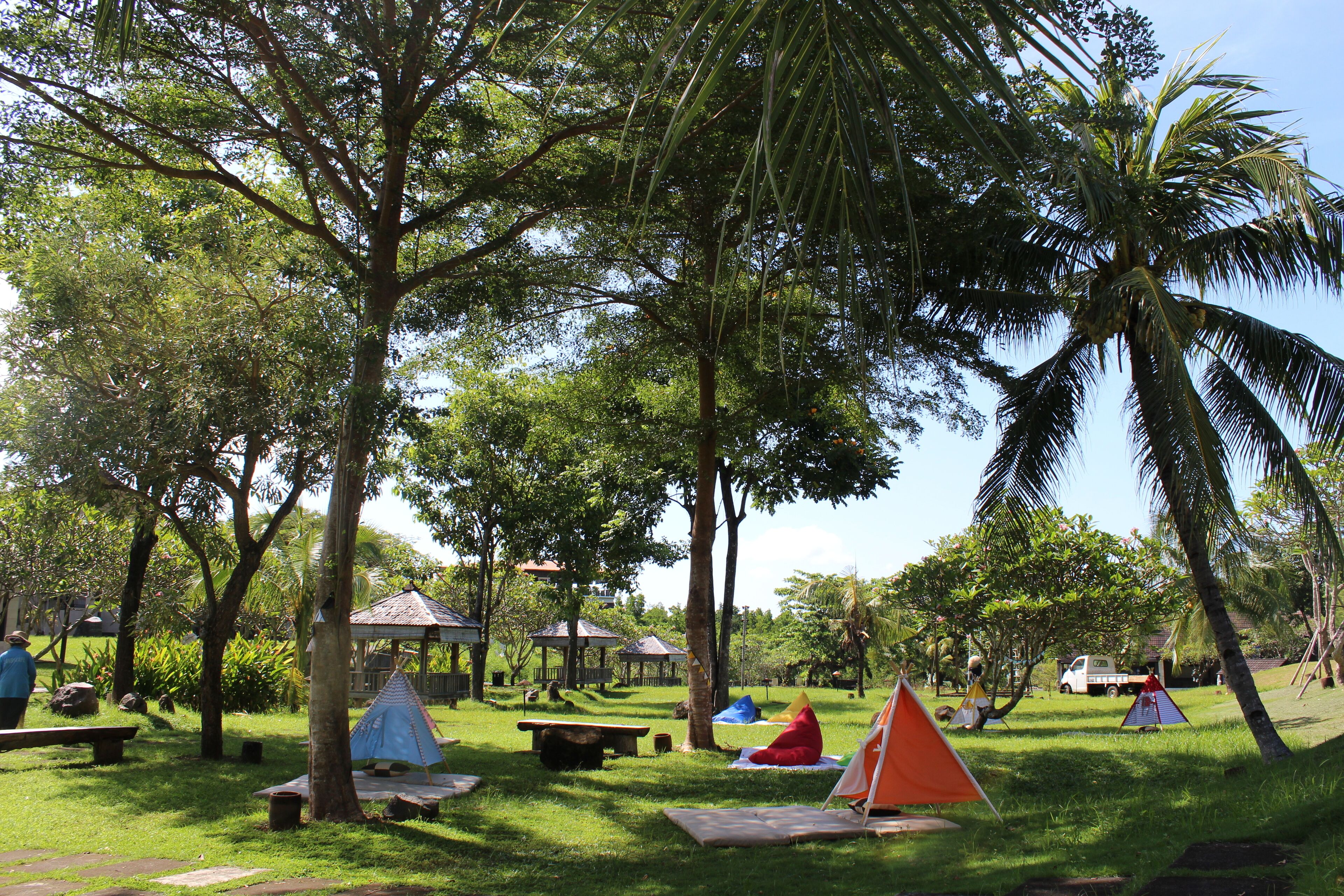 Un parque con mesas de picnic, un pabellón y una tienda de campaña.