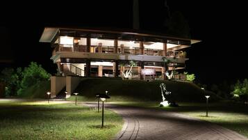 A multi-story hotel with a modern design, featuring balconies and a well-lit entrance.
