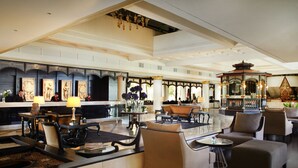 A spacious lobby with a reception desk, seating area, and decorative elements like a fountain and a pagoda-style structure.