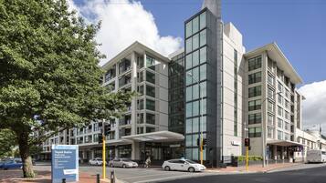 A modern building with multiple floors, large windows, and a prominent entrance area.