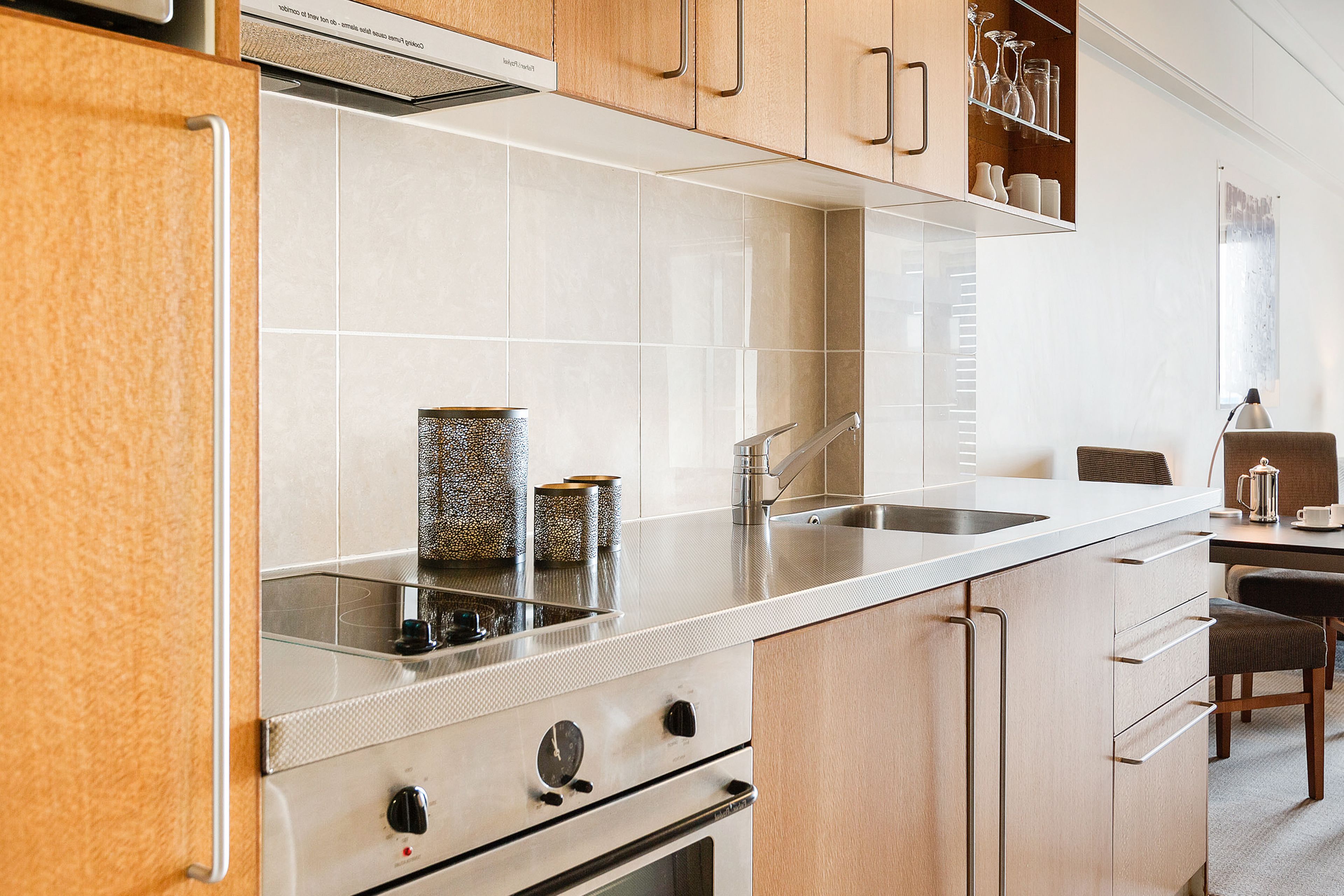 Una cocina moderna con estufa de acero inoxidable, un lavamanos y armarios de madera.