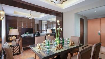 A hotel dining area with a glass table set for six, surrounded by cushioned chairs.