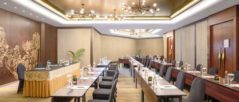 A conference room with long tables, chairs, and a reception desk.