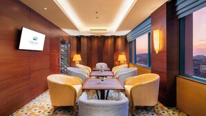 A hotel conference room with a long table, six chairs, and a city view. - Hotel Ciputra Semarang (Semarang)