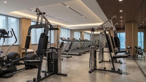A gym with treadmills, elliptical machines, and weight equipment. - Hotel Ciputra Semarang (Semarang)