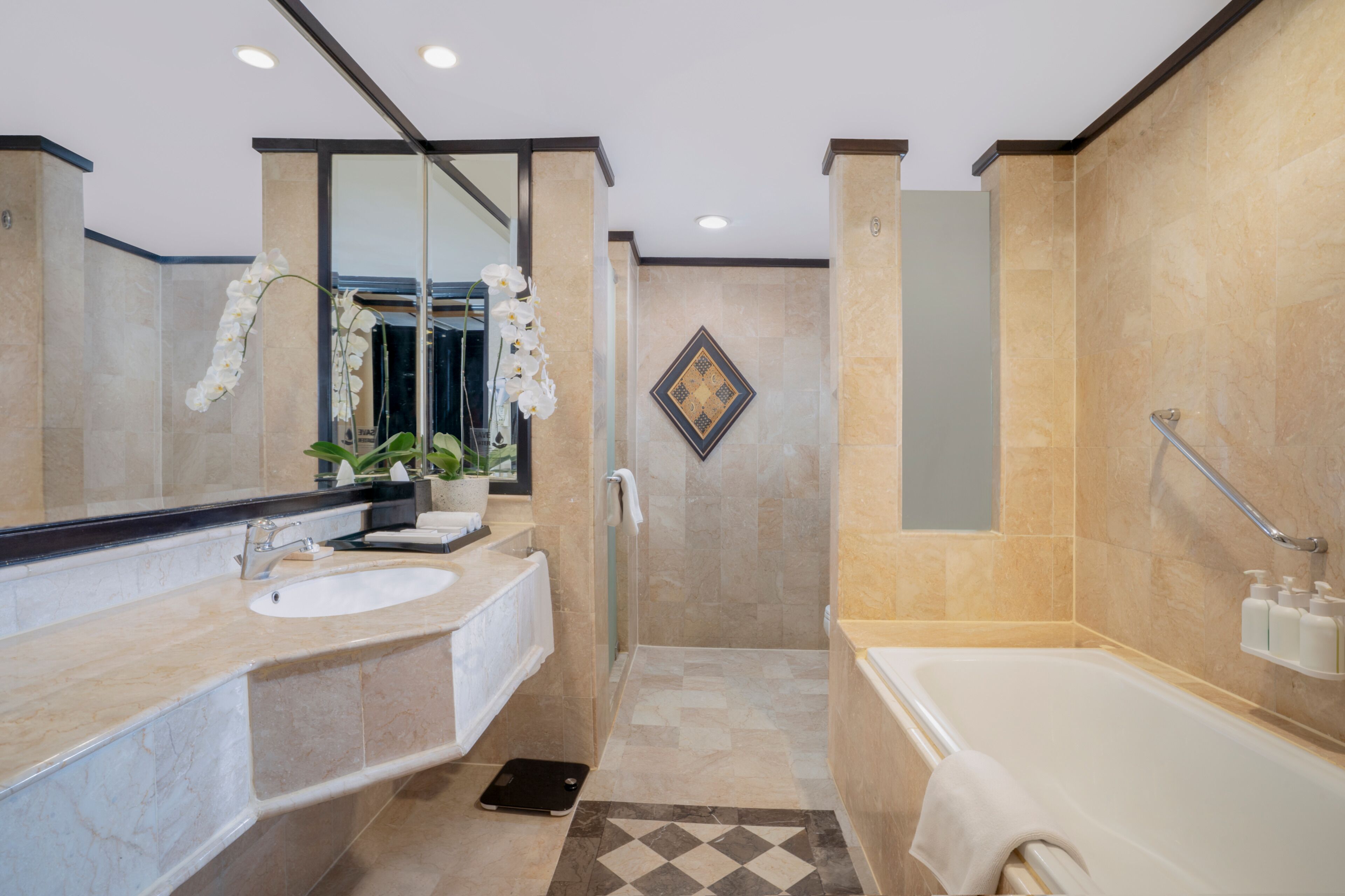 A modern bathroom with a large mirror, two sinks, a shower, and a bathtub.