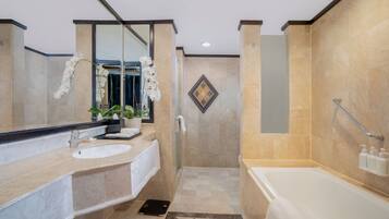 A modern bathroom with a large mirror, two sinks, a shower, and a bathtub.