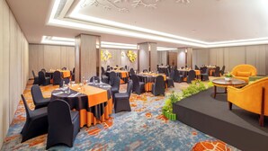 A conference room with tables and chairs, a stage, and a decorative ceiling. - Hotel Ciputra Semarang (Semarang)