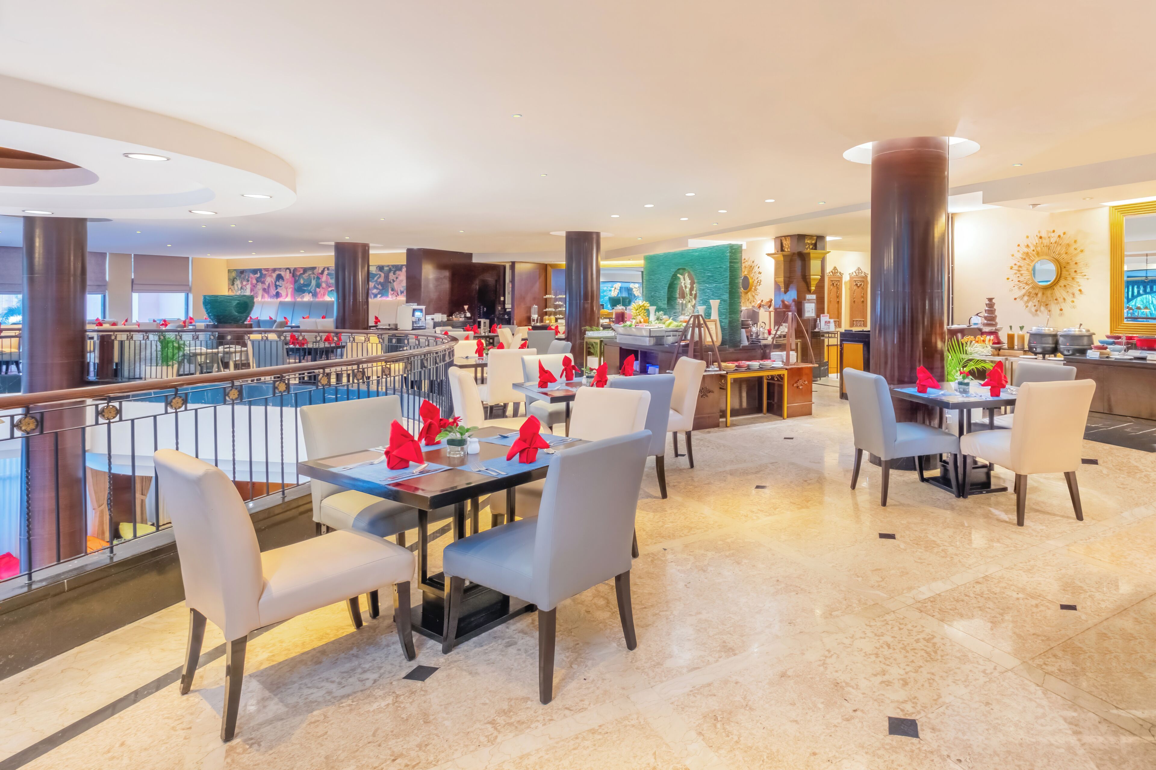 A hotel restaurant with multiple dining tables, chairs, and a bar area.