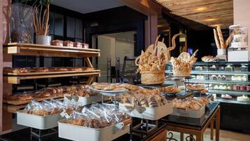 Una vitrina de panadería con diferentes productos horneados y pasteles.