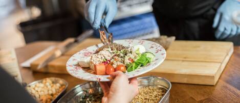 A person serving food from a tray to a plate.