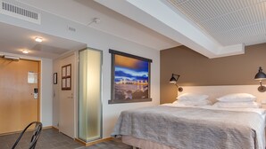 Una camera d'albergo con un letto, una sedia, una scrivania, una finestra e una porta.
