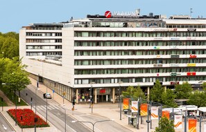 Ein mehrstöckiges Hotel mit modernem Design, mit einem gut sichtbaren H&M Geschäft im Erdgeschoss.