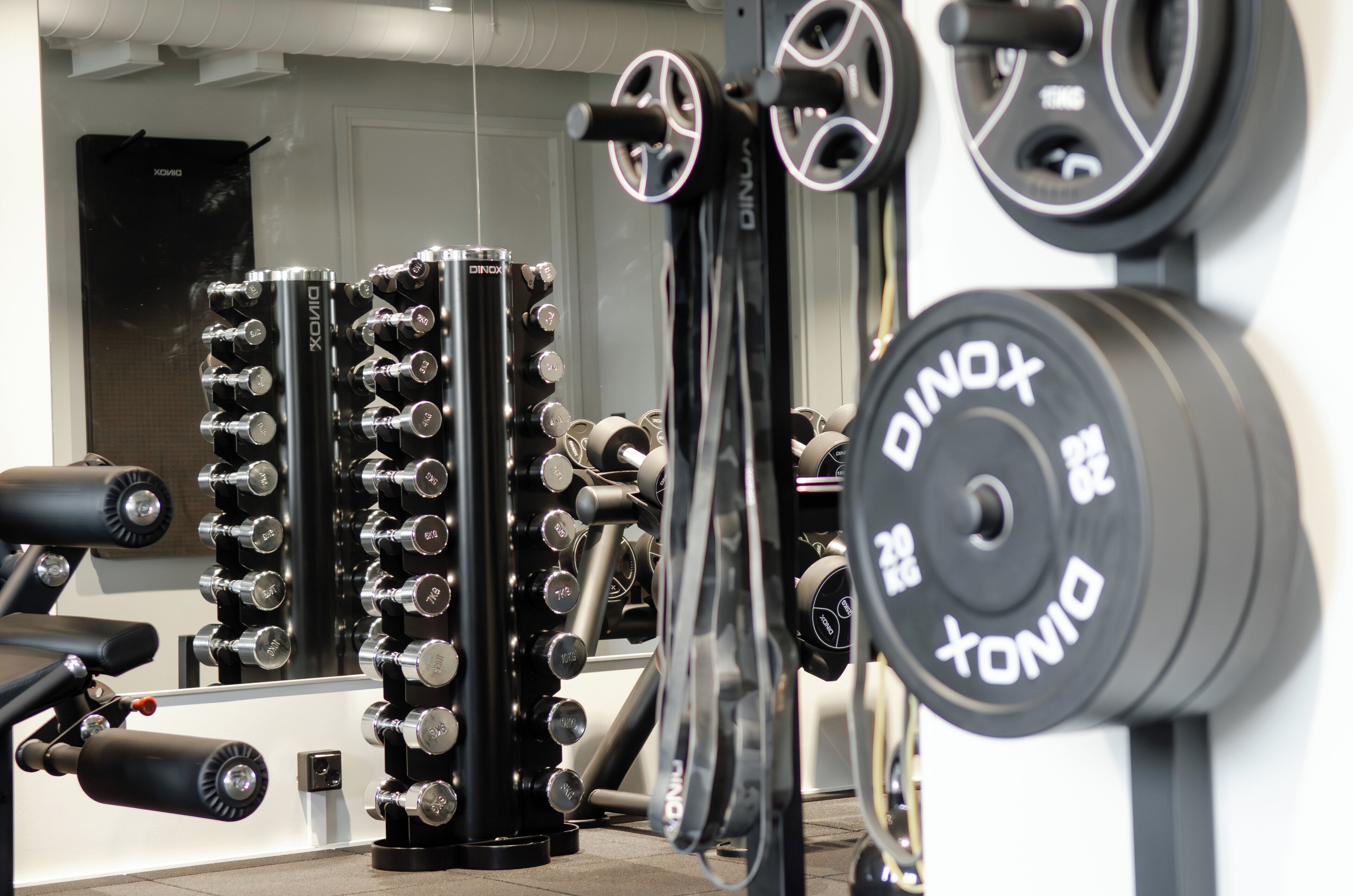 A gym with various weightlifting equipment, including dumbbells and a cable machine.