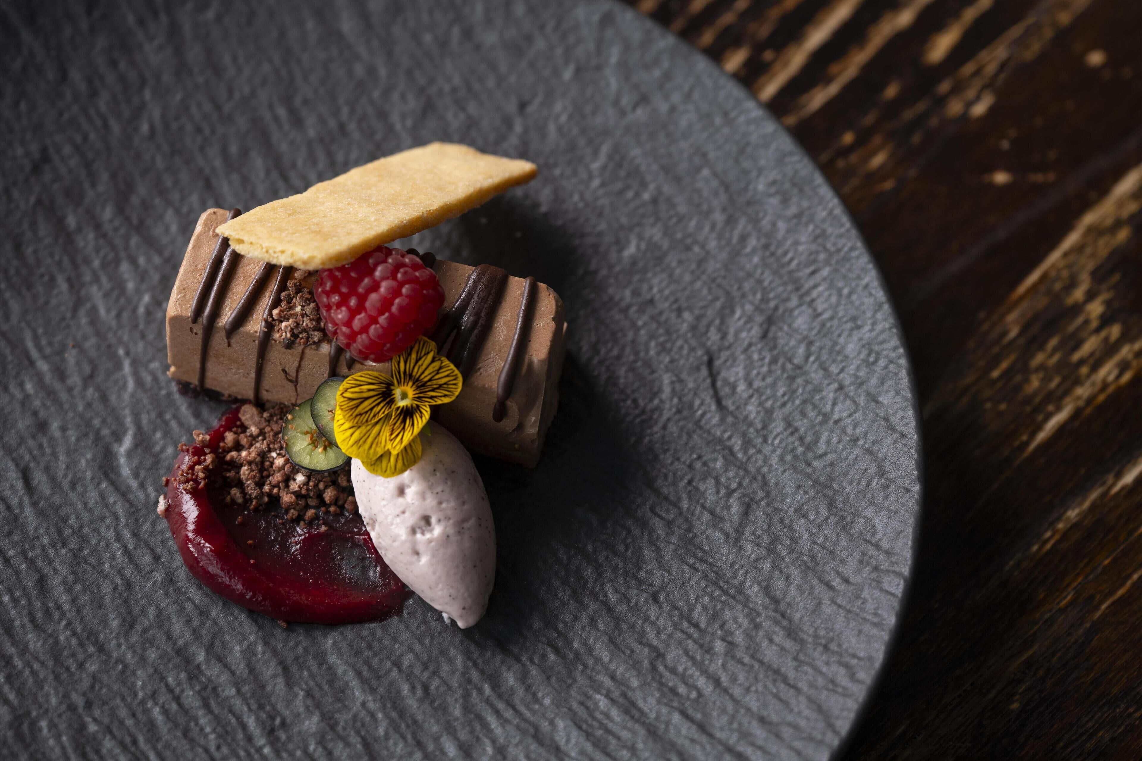 A dessert on a slate plate with various toppings.