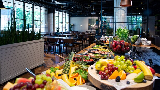 A modern restaurant with a variety of fruits and vegetables displayed on the counter. - Original Sokos Hotel Lappee (Lappeenranta)