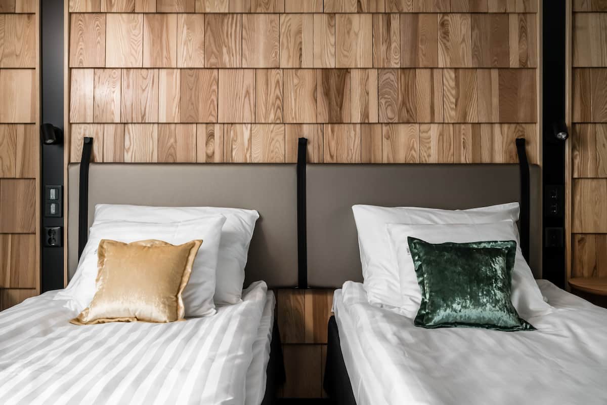 Une chambre d’hôtel avec deux lits, chacun étant équipé d’un oreiller et d’une tête de lit.