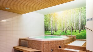 A spa area with a hot tub, wooden steps, and a forest mural on the wall. - Original Sokos Hotel Vaakuna Joensuu (Joensuu)