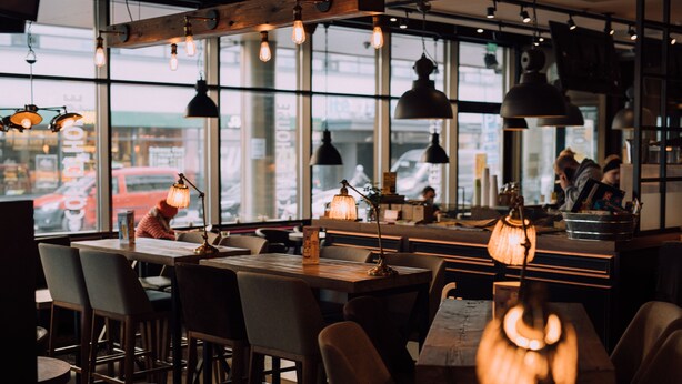 An interior with tables and chairs, pendant lighting, and large windows. - Original Sokos Hotel Vaakuna Joensuu (Joensuu)