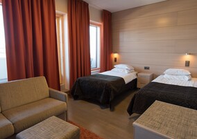 Una habitación de hotel con dos camas, un sofá y una pequeña mesa.