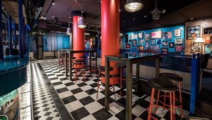 A bar area with checkered flooring, red pillars, and bar stools. - Original Sokos Hotel Vaakuna Joensuu (Joensuu)