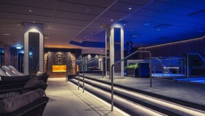 A modern spa area with a heated floor, seating area, and a reception desk.